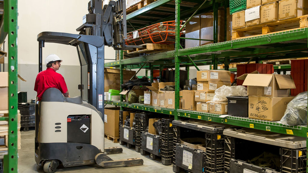A CBO employee using a forklift to move inventory in a Department of National Defence warehouse.