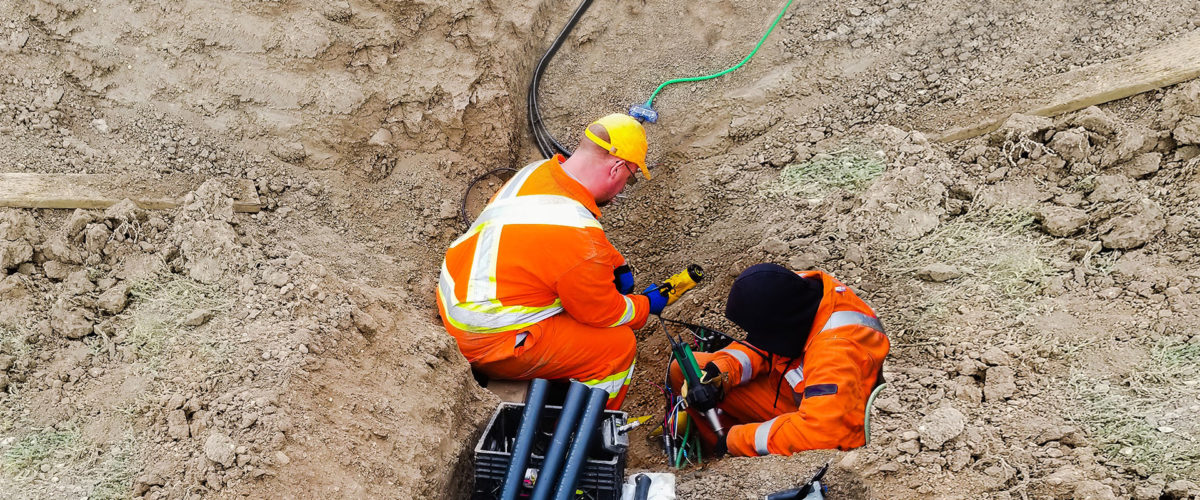 Two CBO employees working on cables in conduit.